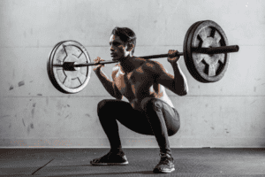 Image of a fit man lifting weights wearing gym pants. Blog named "Protein 101 - All About Protein For Optimal Healing and Health" by tonika health (https://tonikahealth.com.au)